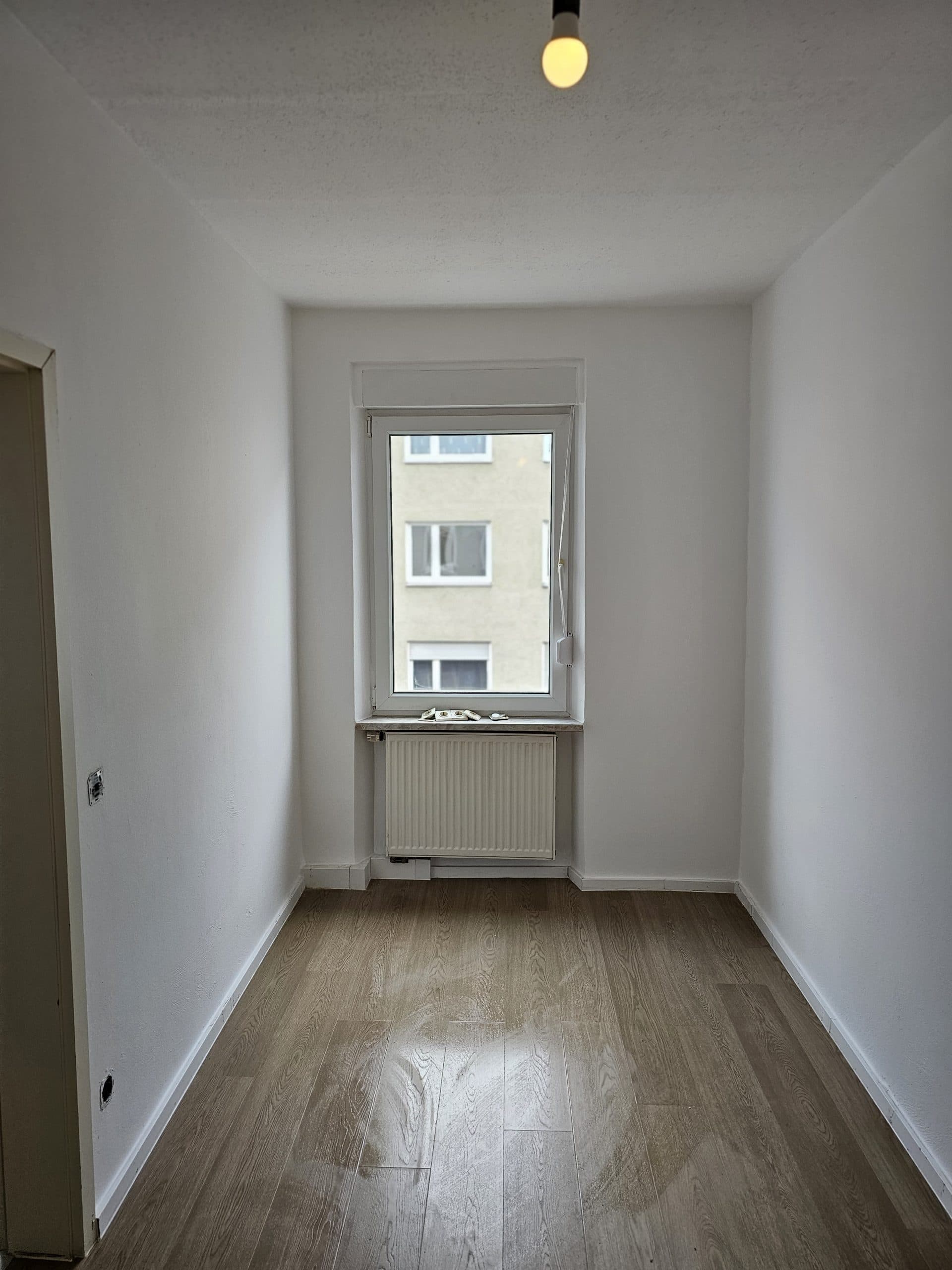 Renoviertes Zimmer mit lackiertem Heizkörper und Laminat